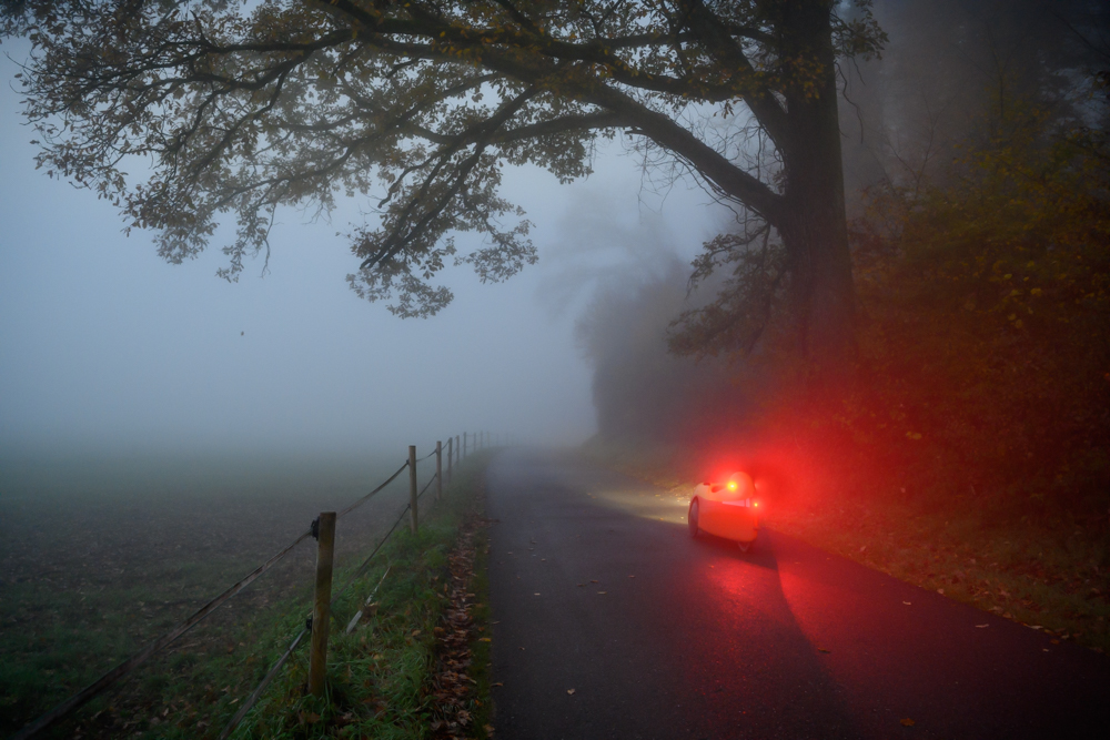 Velomobil mit leuchtendem Bremslicht im Nebel