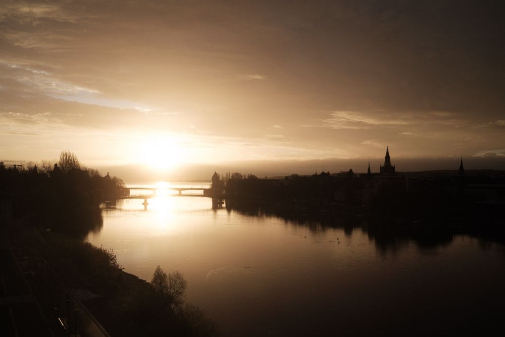 Sonnenaufgang hinter dramatischen Wolken mit der alten Konstanzer Rheinbrücke