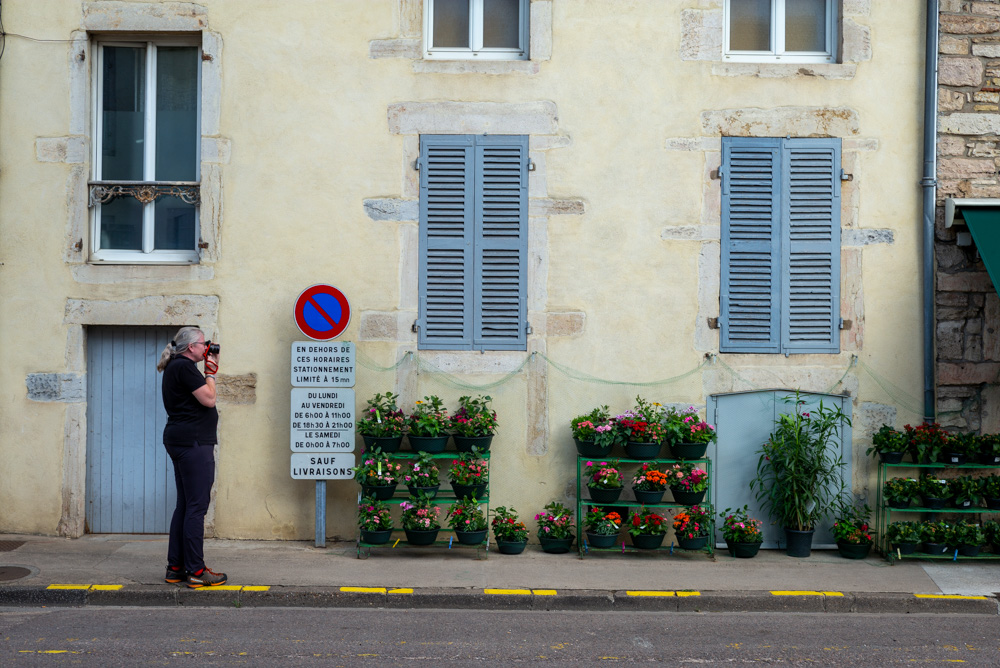 Frau mit Kamera vor einem Blumenladen