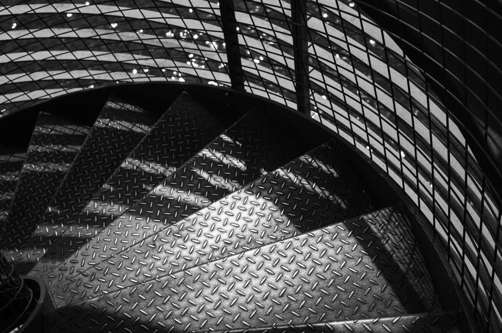 kontrastriches SW-Foto von Metallblechstufen einer Wendeltreppe