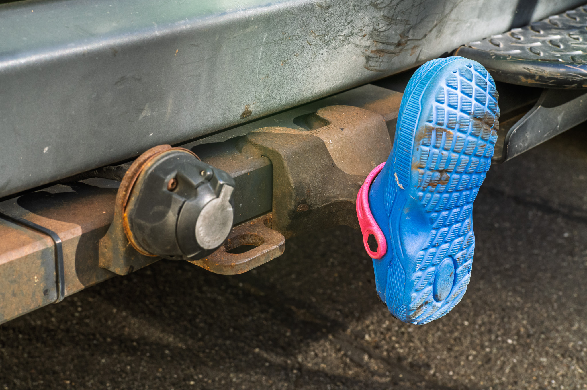 ein blauer Crocs-Schuh, der als Schutz über eine Anhängerkupplung gestülpt wurde
